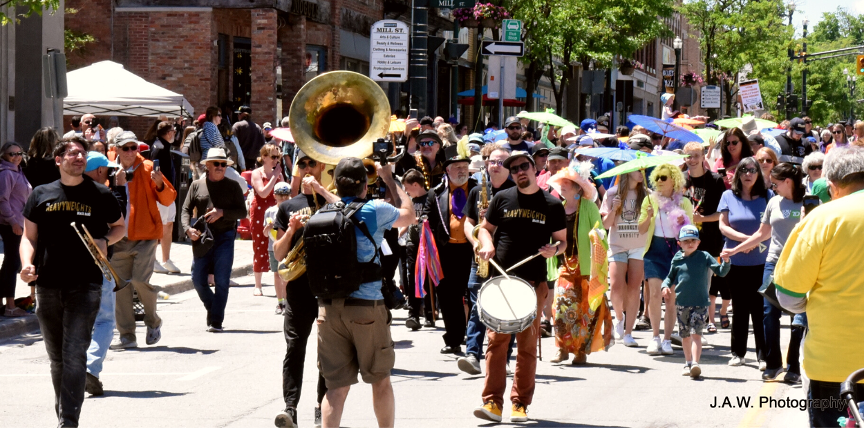 Group of people and musicians walking down sunny street at Orangeville Blues and Jazz Festival